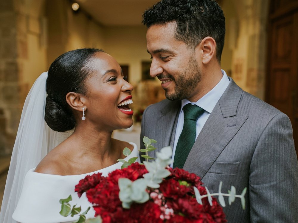 Novios sonrientes con ramo de novia