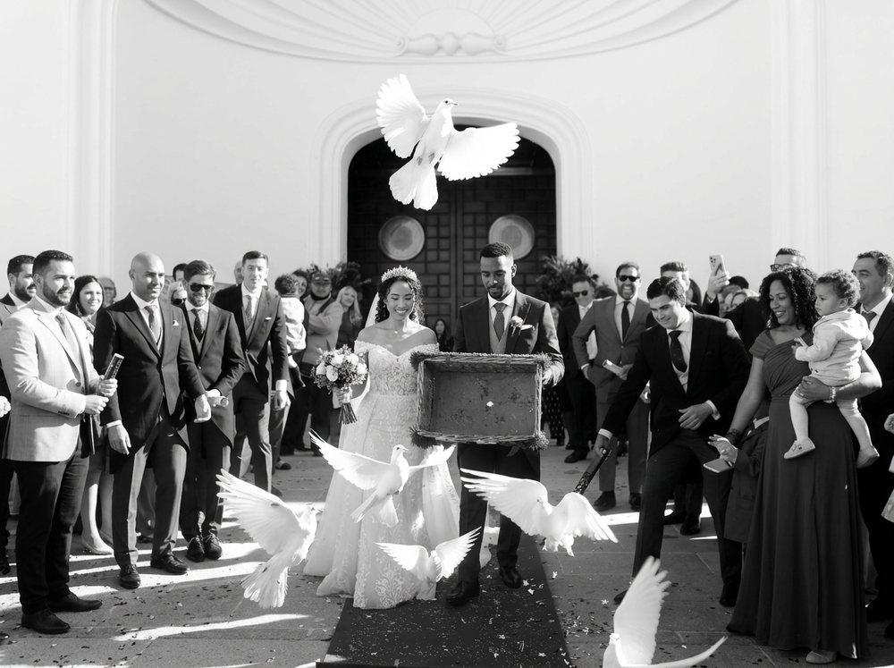 Novios saliendo de la ceremonia entre palomas