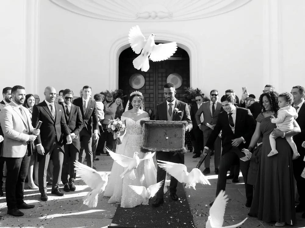 Novios saliendo de la ceremonia entre palomas
